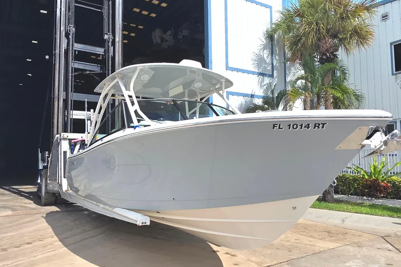 Slide: The Image of 2019 Cobia 280 Dual Console boat being moved from storage facility. - 2