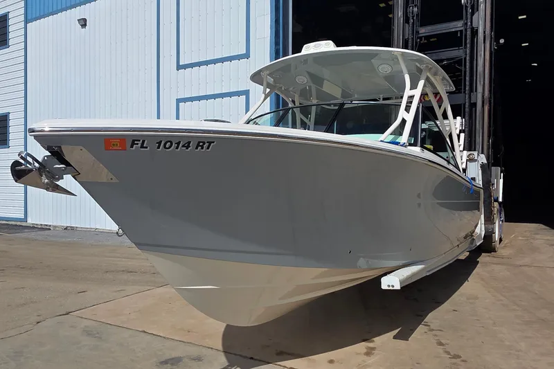 Slide: The Image of 2019 Cobia 280 Dual Console boat in a marina, front view. - 3