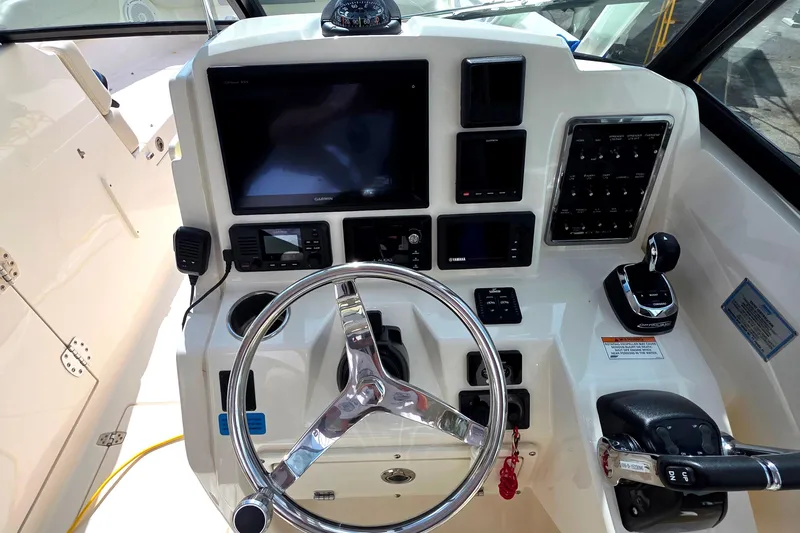 Slide: The Image of 2019 Cobia 280 Dual Console boat dashboard with steering wheel and control panel. - 25