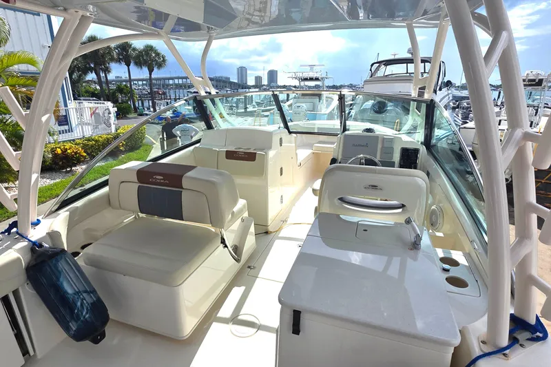 Slide: The Image of 2019 Cobia 280 Dual Console boat interior with seating and helm, docked at marina. - 24