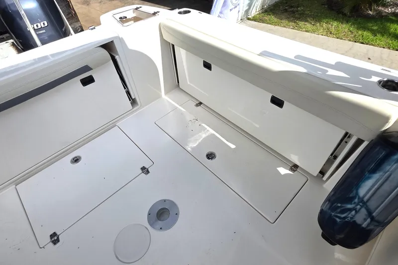 Slide: The Image of 2019 Cobia 280 Dual Console boat interior with storage compartments and seating. - 9