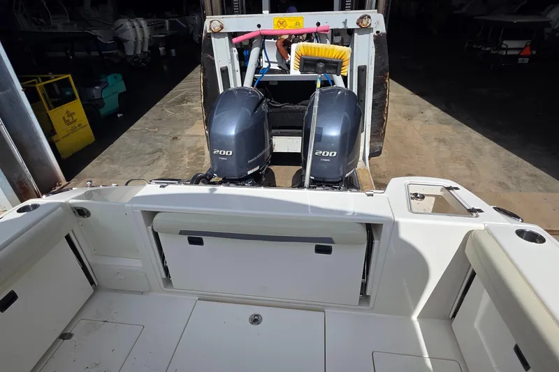 Slide: The Image of 2019 Cobia 280 Dual Console with twin 200 horsepower engines in a storage facility. - 22