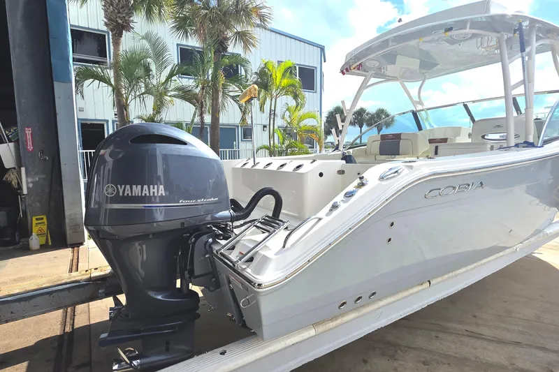 Slide: The Image of 2019 Cobia 280 Dual Console boat with Yamaha engine, docked near palm trees. - 10