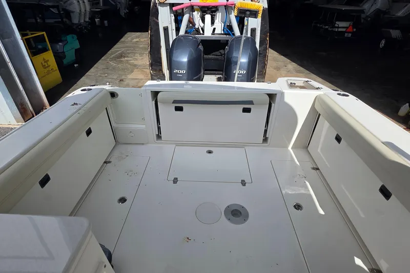 Slide: The Image of 2019 Cobia 280 Dual Console boat interior with twin 200 engines in a garage setting. - 21