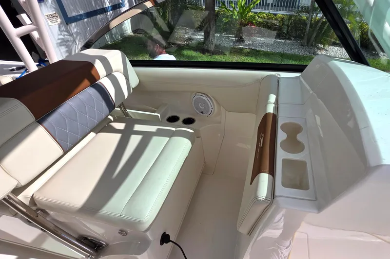 Slide: The Image of 2019 Cobia 280 Dual Console interior with cushioned seating and cup holders. - 8