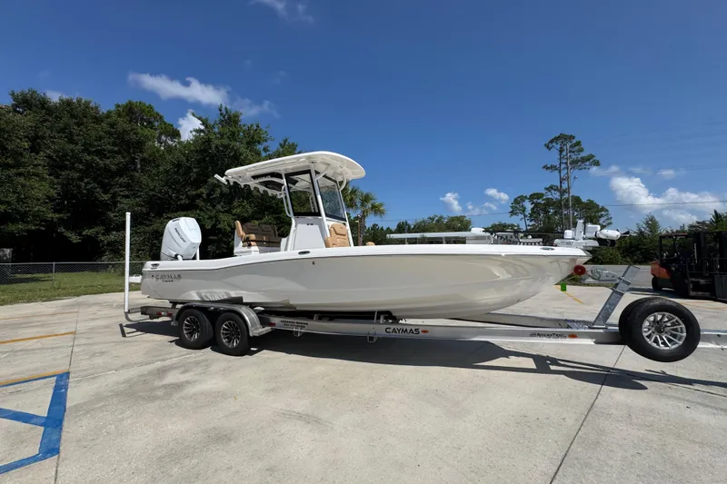 Slide: The Image of 2027 Caymas 26 HB boat on trailer, parked outdoors under clear blue sky. - 9