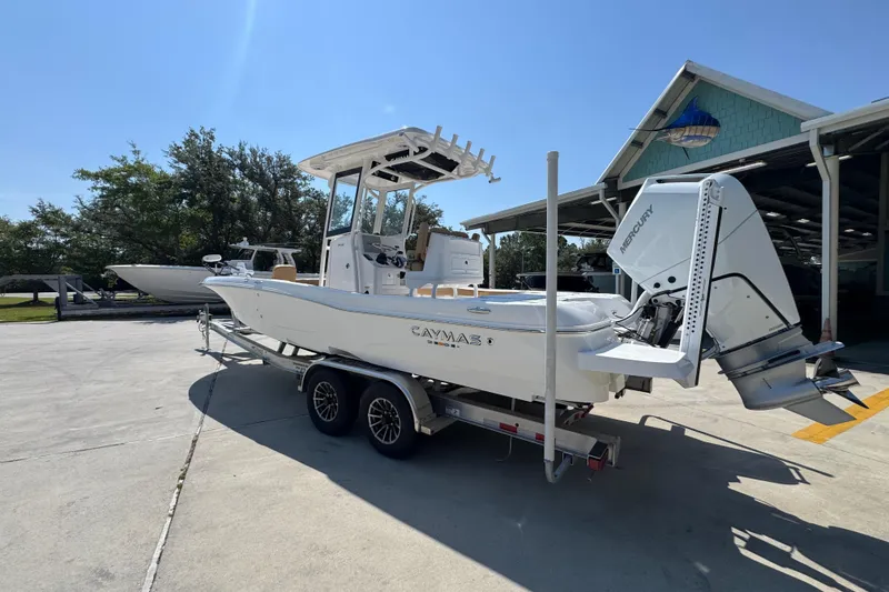 Slide: The Image of 2027 Caymas 26 HB boat on trailer, parked outdoors under clear blue sky. - 18