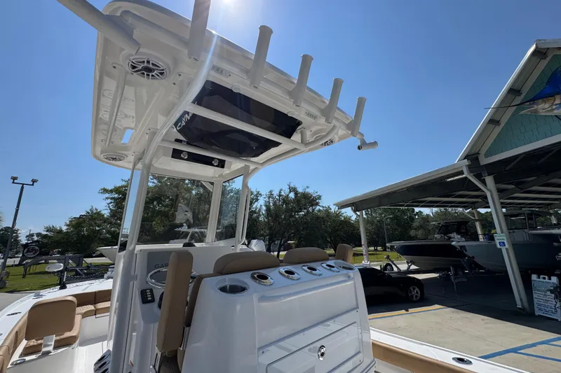 Slide: The Image of 2027 Caymas 26 HB boat with T-top and rod holders, displayed outdoors. - 38