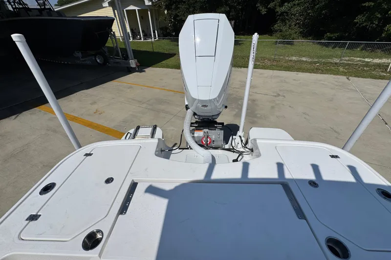Slide: The Image of 2027 Caymas 26 HB boat stern view with outboard motor in a driveway. - 40