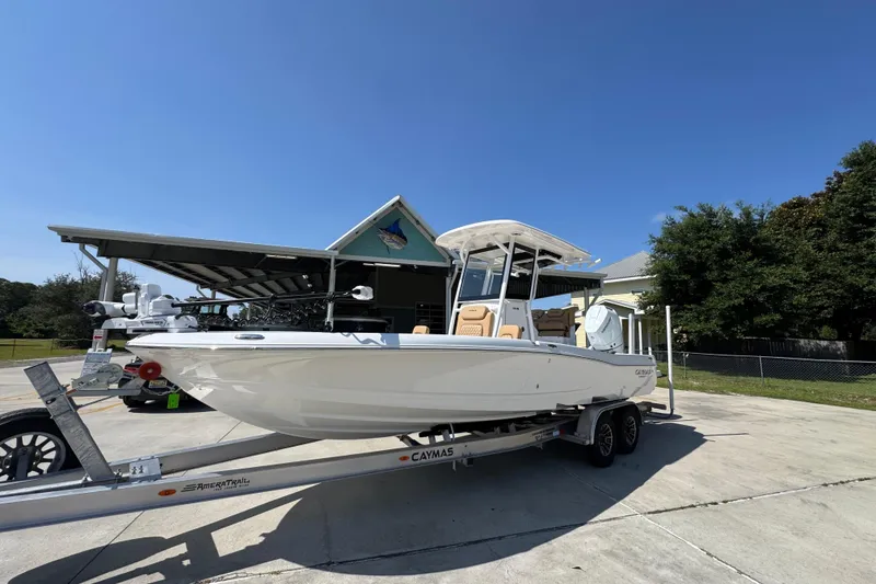 Slide: The Image of 2027 Caymas 26 HB boat on trailer, parked outdoors under clear blue sky. - 3