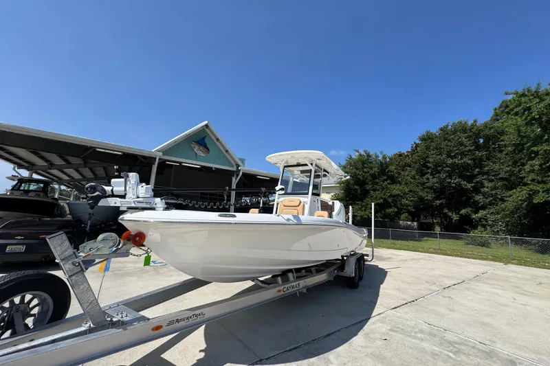 Slide: The Image of 2027 Caymas 26 HB boat on trailer, parked outdoors under clear blue sky. - 4