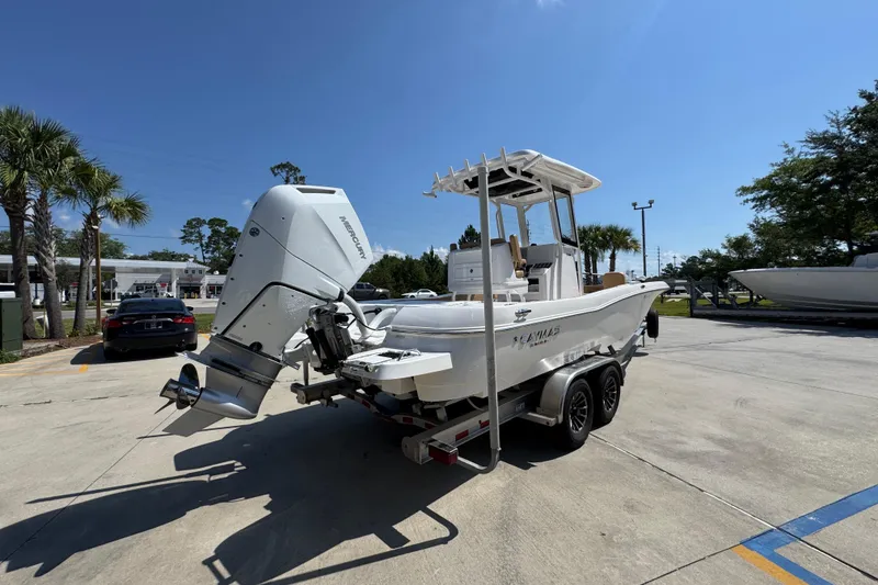 Slide: The Image of 2027 Caymas 26 HB boat on trailer with Mercury outboard engine, parked outdoors. - 13