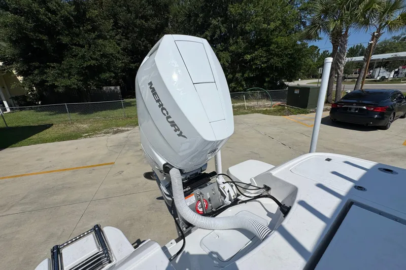 Slide: The Image of 2027 Caymas 26 HB boat with Mercury outboard motor in a sunny parking lot. - 43