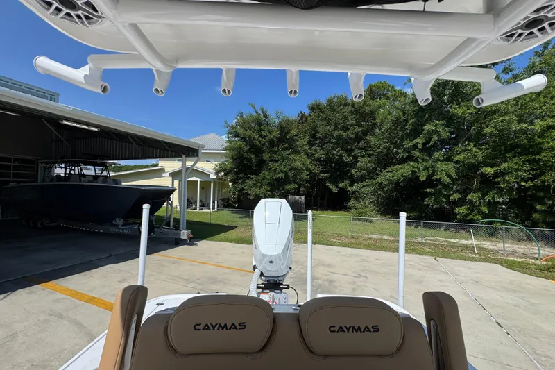 Slide: The Image of 2027 Caymas 26 HB boat parked outdoors, showcasing rod holders and seating. - 32