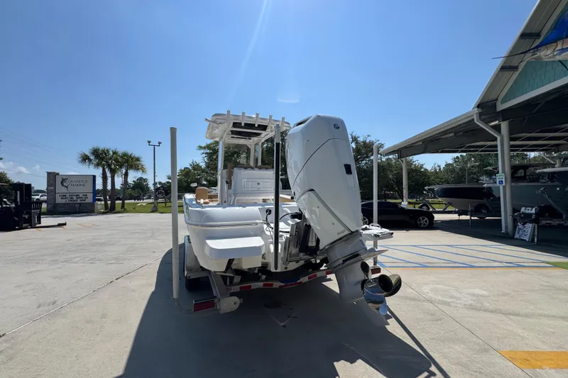 Slide: The Image of 2027 Caymas 26 HB boat with outboard motor on trailer in sunny marina. - 16