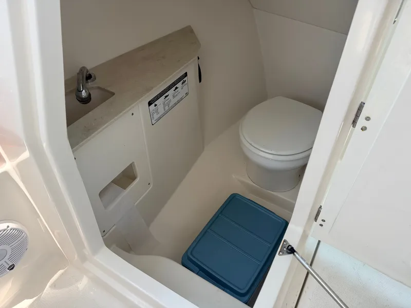 Slide: The Image of Interior of a 2022 Sailfish 276 DC featuring a toilet, sink, and storage area. - 14