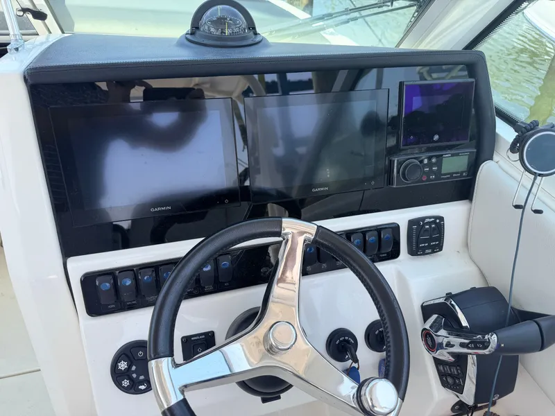 Slide: The Image of The image shows the helm of a 2022 Sailfish 276 DC with two screens and a compass. - 15