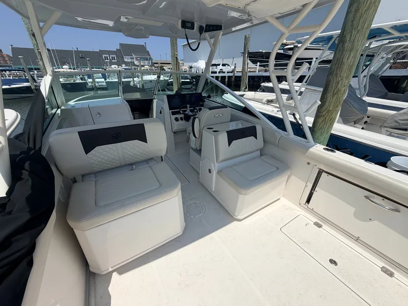 Slide: The Image of The image shows the cockpit of a 2022 Sailfish 276 DC with white cushioned seats and a helm station. - 19