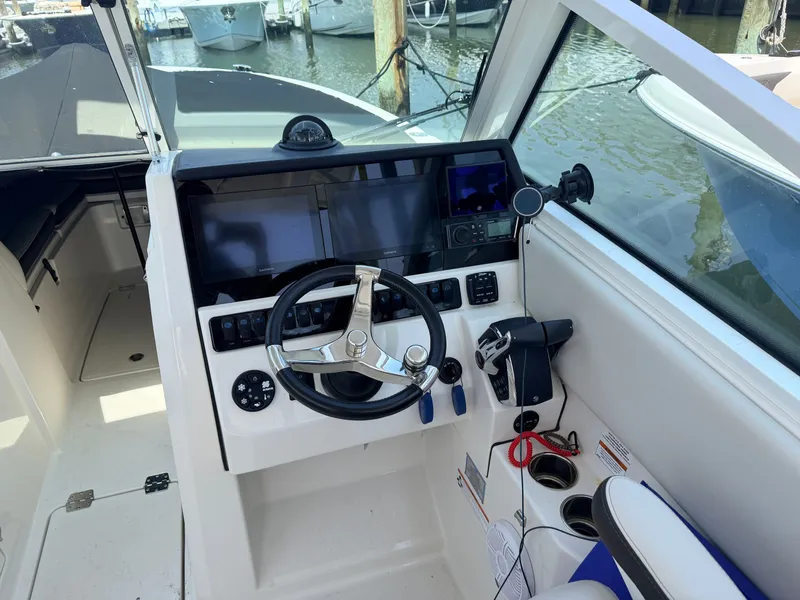 Slide: The Image of The image shows the helm of a 2022 Sailfish 276 DC with modern instruments and a sleek steering wheel. - 16