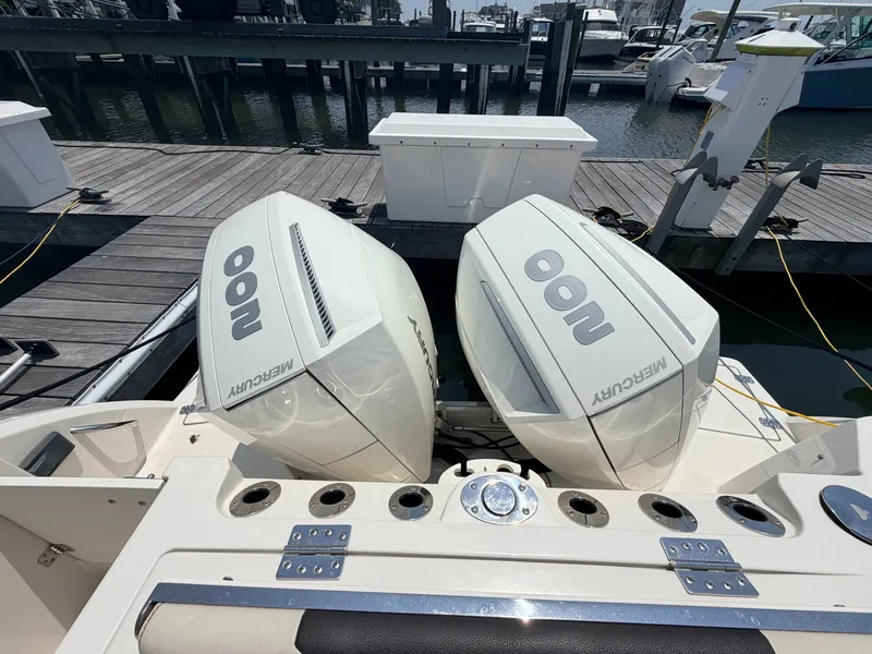 Slide: The Image of Two Mercury outboard engines on a boat at the dock, surrounded by water and other boats. - 20