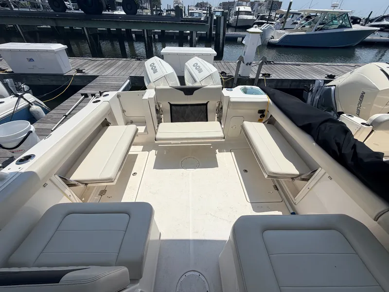 Slide: The Image of The image shows the cockpit of a 2022 Sailfish 276 DC boat with beige seating and two engines. - 21