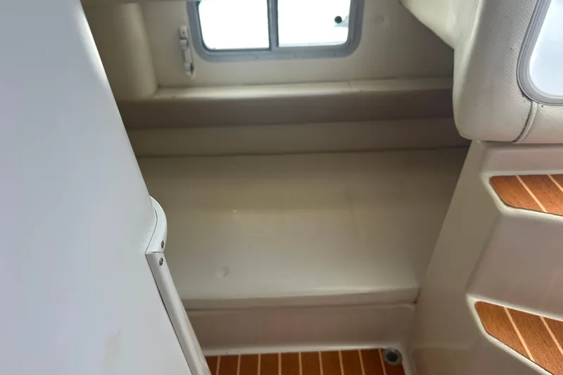 Slide: The Image of Interior cabin view of a 1994 Pro-Line 2950 Walkaround boat, featuring a compact sleeping area. - 6
