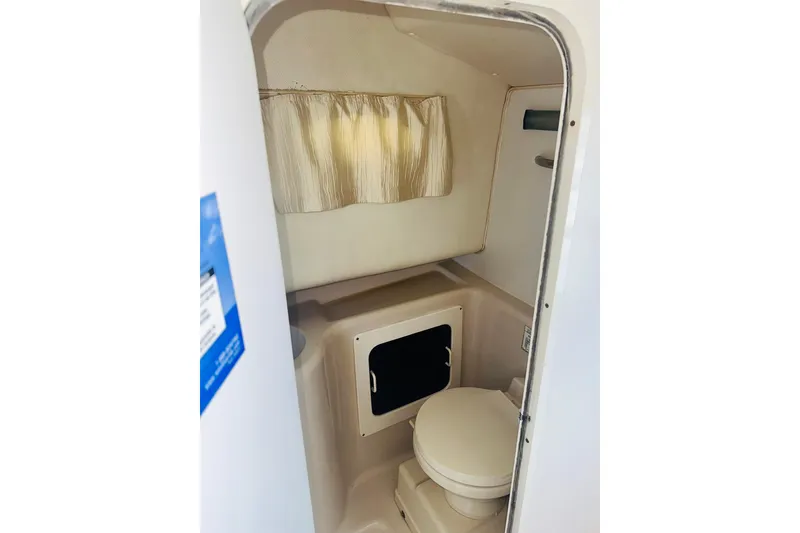 Slide: The Image of 1994 Pro-Line 2950 Walkaround boat interior with compact bathroom and curtain. - 7