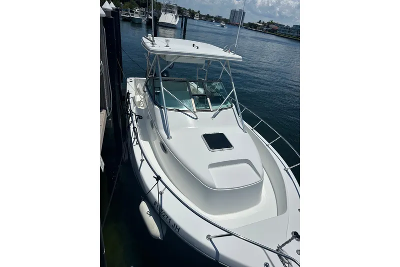 The Image of 1994 Pro-Line 2950 Walkaround boat docked in a marina, showcasing sleek design and spacious deck. - 1