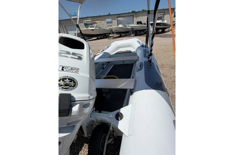 Slide: The Image of 2022 Achilles inflatable boat with motor, displayed outdoors at a dealership. - 5