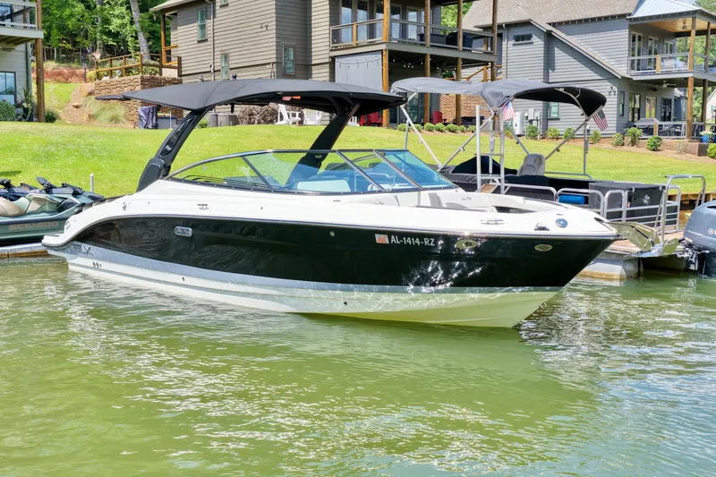 Slide: The Image of 2025 Sea Ray SLX 280 boat docked by lakeside homes. - 2