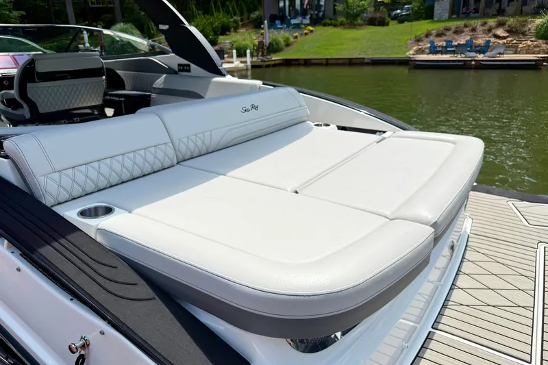 Slide: The Image of 2025 Sea Ray SLX 280 boat with luxurious white seating by the water. - 32
