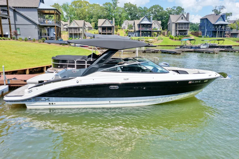 Slide: The Image of 2025 Sea Ray SLX 280 boat docked on a serene lake with waterfront homes. - 4