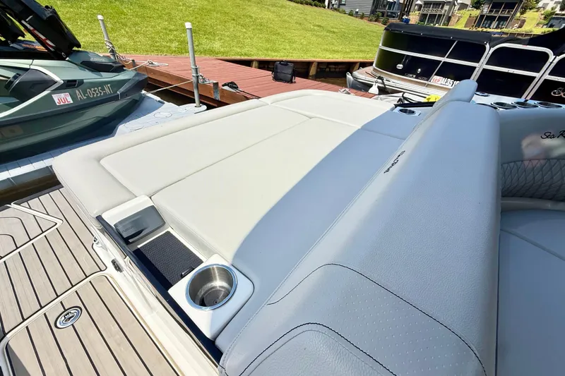 Slide: The Image of 2025 Sea Ray SLX 280 boat with sleek seating and cup holder, docked near other vessels. - 31