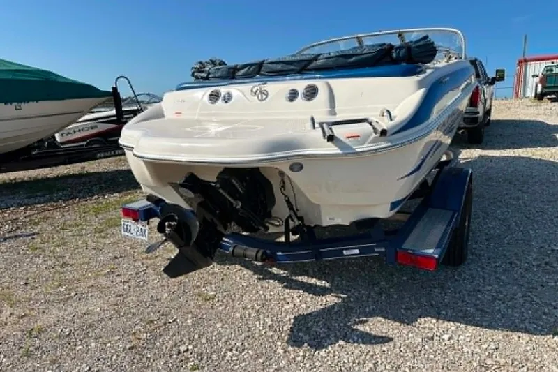 Slide: The Image of 2006 Tahoe Q6 Sport boat on trailer, parked on gravel lot under clear blue sky. - 10