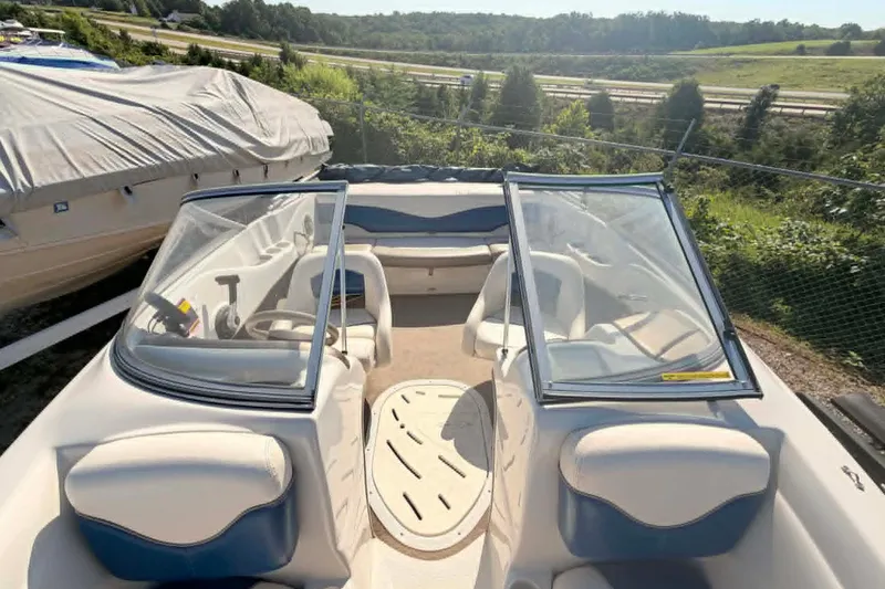 Slide: The Image of 2006 Tahoe Q6 Sport boat with open cockpit and seating, parked outdoors. - 1