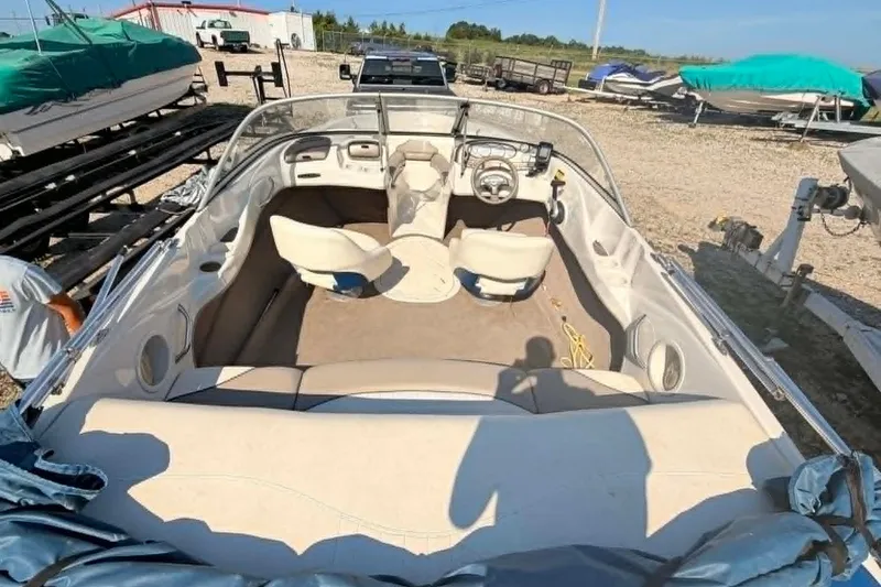 Slide: The Image of 2006 Tahoe Q6 Sport boat interior with seating and steering wheel, parked outdoors. - 6