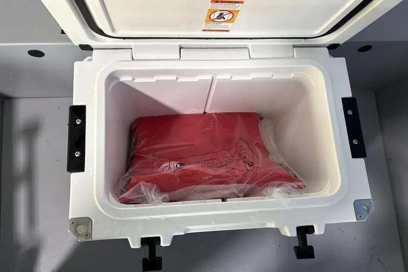 Slide: The Image of Open storage compartment in 2026 Tracker Bass Tracker Classic CC boat with red item inside. - 14