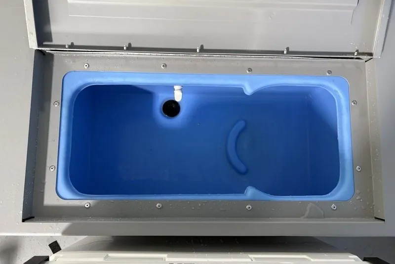 Slide: The Image of Livewell compartment in 2026 Tracker Bass Tracker Classic CC boat, featuring a blue interior. - 19