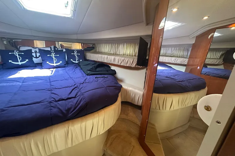 Slide: The Image of Luxurious cabin interior of 2001 Sea Ray 410 Sundancer with nautical-themed bedding. - 16