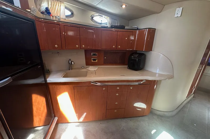 Slide: The Image of Luxurious 2001 Sea Ray 410 Sundancer yacht kitchen with wood cabinetry and modern appliances. - 23