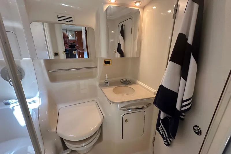 Slide: The Image of Luxurious bathroom in 2001 Sea Ray 410 Sundancer yacht, featuring sink, mirror, and towel. - 18