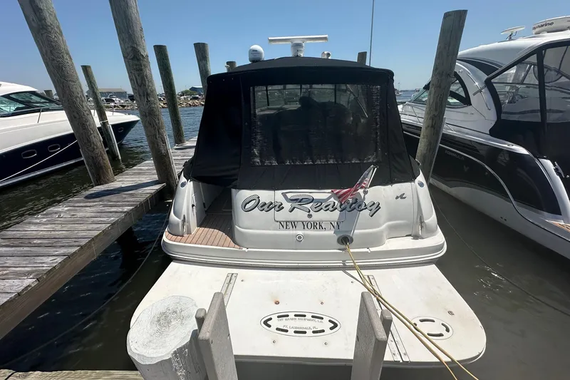 Slide: The Image of 2001 Sea Ray 410 Sundancer docked at marina, rear view with black cover. - 5