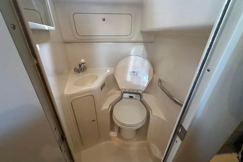 Slide: The Image of Compact bathroom in 2001 Sea Ray 410 Sundancer yacht, featuring toilet and sink. - 21