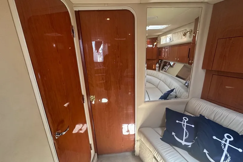 Slide: The Image of Interior of 2001 Sea Ray 410 Sundancer with wood paneling and nautical-themed cushions. - 12