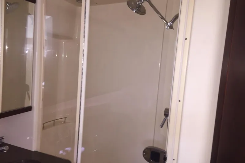 Slide: The Image of Shower area in 2001 Sea Ray 410 Sundancer yacht, featuring glass door and chrome fixtures. - 13