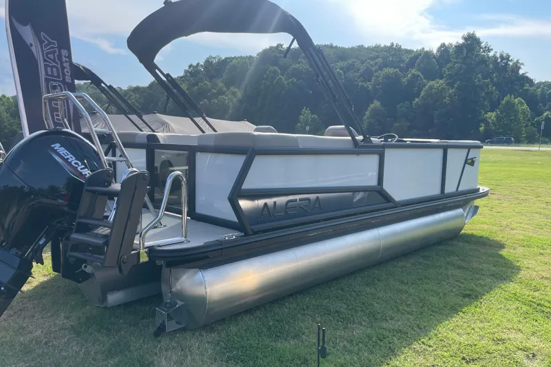 Slide: The Image of 2026 Alera A22 pontoon boat displayed on grass with Mercury engine. - 1