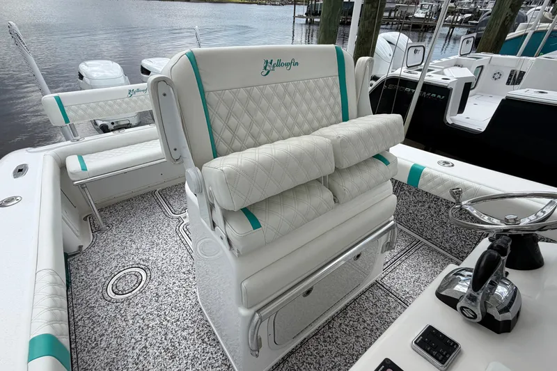 Slide: The Image of 2002 Yellowfin 31 Center Console boat with white and teal seating, docked by the water. - 25