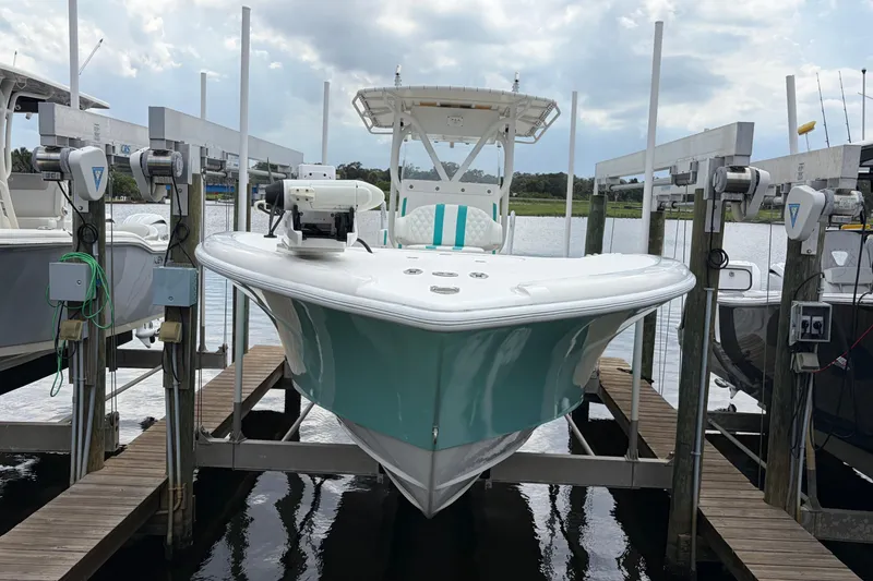 Slide: The Image of 2002 Yellowfin 31 Center Console boat docked on a lift, featuring a sleek design. - 7