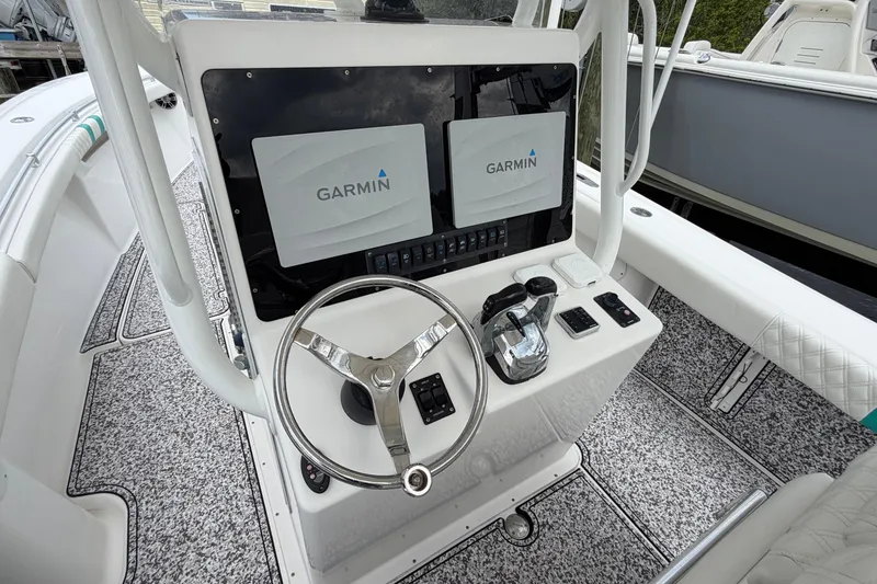 Slide: The Image of 2002 Yellowfin 31 Center Console boat helm with Garmin displays and steering wheel. - 21