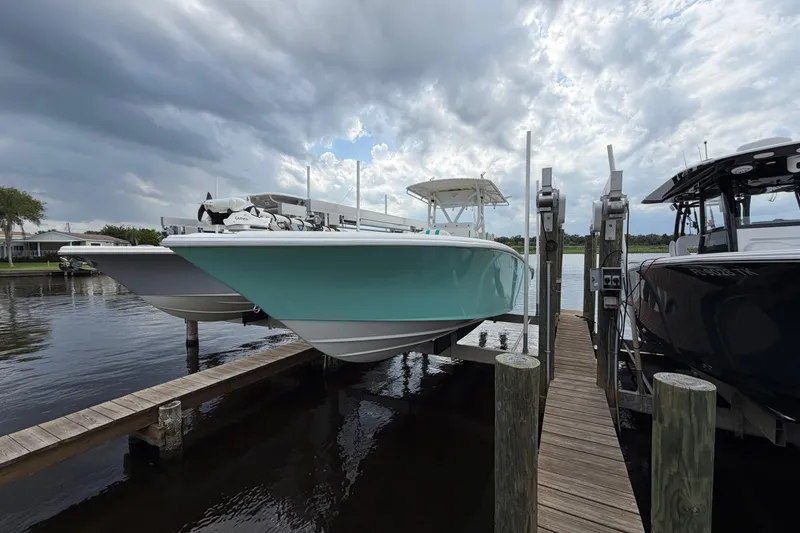 Slide: The Image of 2002 Yellowfin 31 Center Console boat docked under cloudy skies. - 2